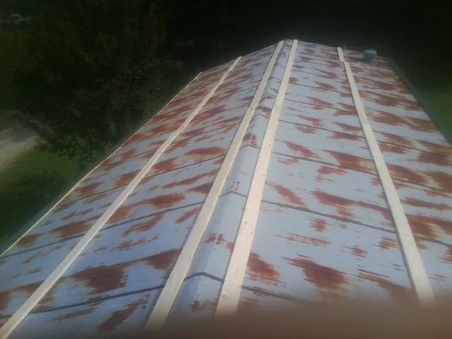 Rusted metal roof panels with new wood purlins before replacement — Storm Damage Roof Repair in Castella by Roofing Brothers