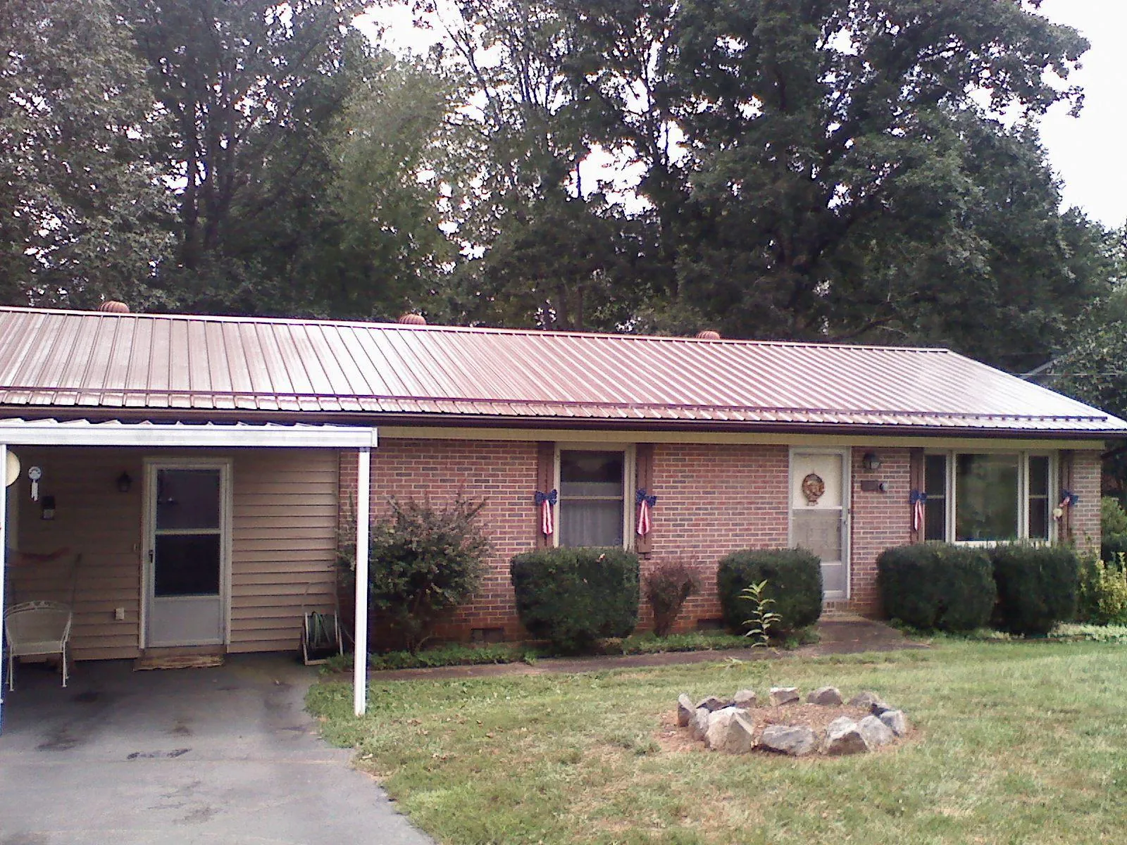 Bronze metal roof and carport on a brick ranch home — Roof Repair work by our crew in Castella