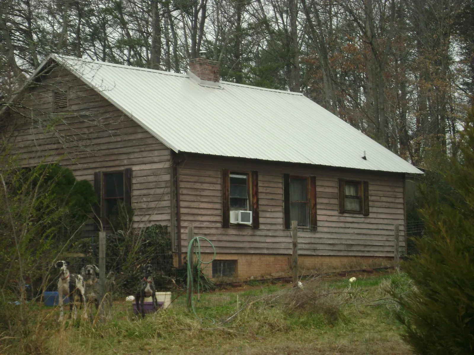 White metal roof on an old wood sided farmhouse, from a Metal Roof Installation job in Castella